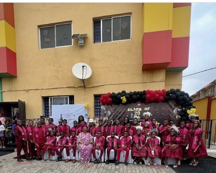 The Class of 2026 in graduation gowns, gathered in front of the school building
