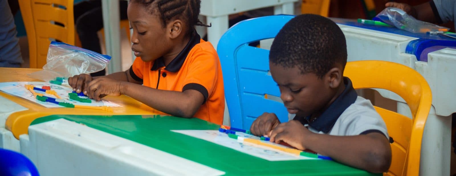 Pupils in B and B School uniform working on a learning activity at their classroom desks